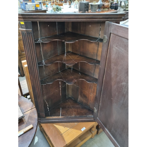 475 - A 19th Century mahogany hanging Corner Cupboard with single panelled door enclosing shaped shelves, ... 