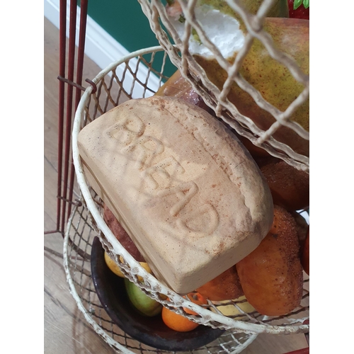 480 - A three-tier fruit and vegetable Stand containing a selection of simulated fruit and bread, (R6)