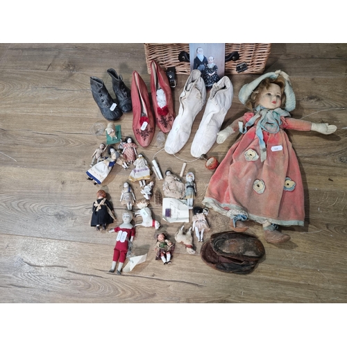 505 - A cloth Dolls in costume, a selection of Shoes, a Basket containing small Dolls, (R5)