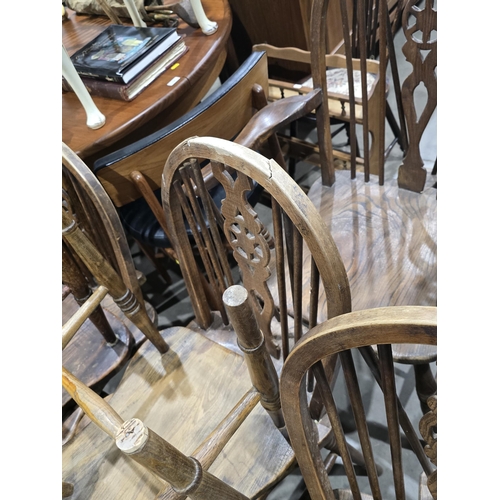 528 - A set of ten ash and elm wheelback Dining Chairs with shaped seats on turned supports and stretchers... 