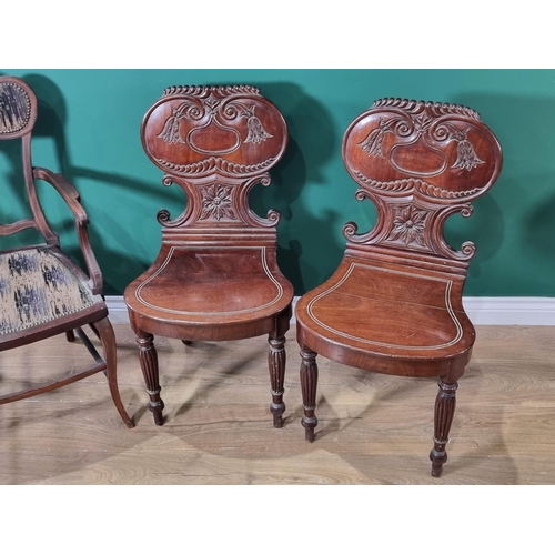 546 - A pair of Victorian mahogany Hall Chairs with carved backs and an Edwardian Elbow Chair with satinwo... 