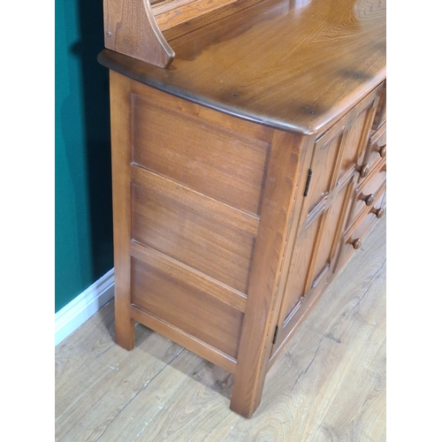 549 - An Ercol elm Dresser with detachable rack, fitted cutlery drawer above three more drawers, flanked b... 