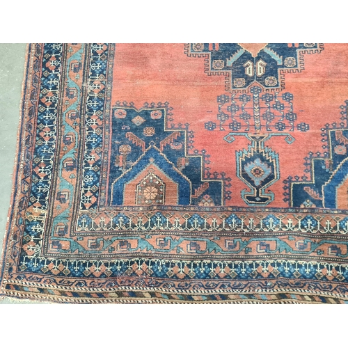 559 - A Persian style terra cotta ground woollen Rug, 6ft 5