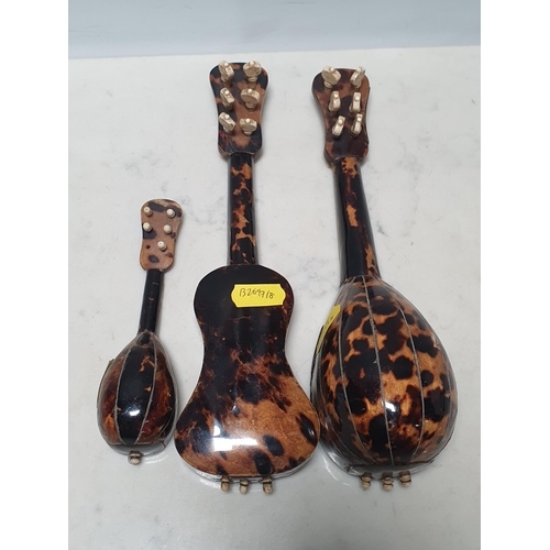 566 - A miniature bone and tortoiseshell Guitar, along with two similar mandolins, longest 9in;(3), (R6)