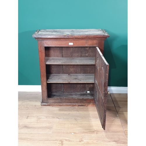 615 - An antique oak Wall Cupboard with moulded cornice, with single arched panelled door enclosing two fi... 