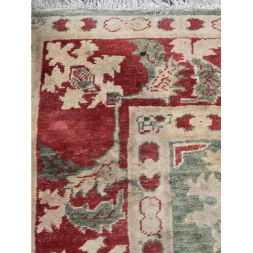 624 - A Turkish style green and red ground Carpet with multiple borders and stylized palmettes, 8ft 6