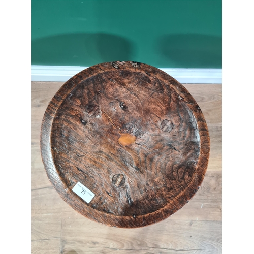 73 - An antique primitive Welsh Stool in elm and and ash with dished circular top on three splayed legs, ... 