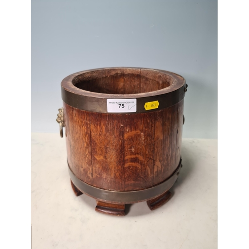 75 - A brass bound oak circular Pot with lion mask and ring handles, 10in diam