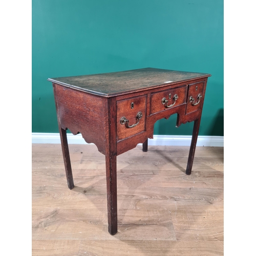 77 - An 18th Century oak Lowboy fitted three drawers around a shaped apron on chamfered square legs, 2ft ... 