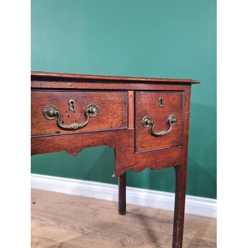 77 - An 18th Century oak Lowboy fitted three drawers around a shaped apron on chamfered square legs, 2ft ... 