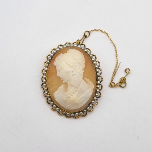 256 - A carved shell Cameo Brooch in a frame of simulated pearls surrounded by gold metal twisted wire fra... 