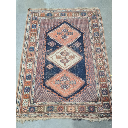 29 - A bordered Persian Rug with stepped triple medallion on  a red and blue ground, 5ft 10in x 4ft 1in