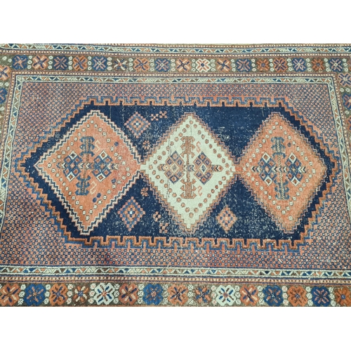 29 - A bordered Persian Rug with stepped triple medallion on  a red and blue ground, 5ft 10in x 4ft 1in