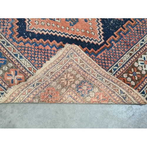 29 - A bordered Persian Rug with stepped triple medallion on  a red and blue ground, 5ft 10in x 4ft 1in