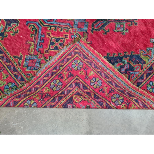 30 - A bordered Turkey Carpet with geometric design on a red ground, 6ft x 8ft 6in