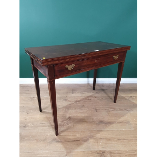 32 - A 19th century mahogany Tea Table with rectangular fold-over top above frieze drawer on square taper... 