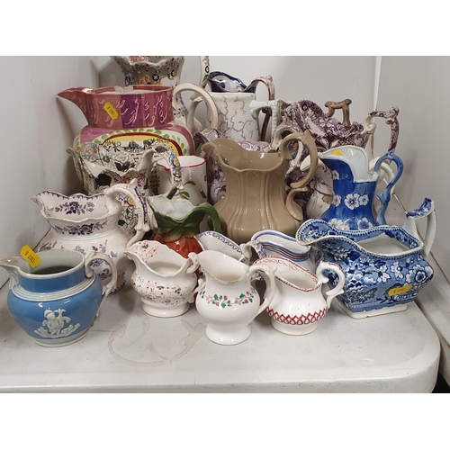 324 - A large collection of assorted ceramic Jugs to include a large pink lustre verse Jug, A/F, etc, (R4)