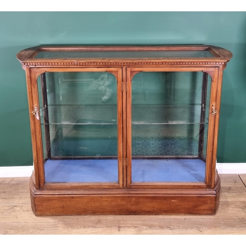 38 - A walnut glazed Display Cabinet, rectangular with rounded ends and fitted a pair of doors,  5ft W x ... 