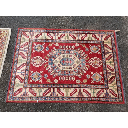 587 - A bordered Persian style Rug with central medallion on a red ground, 4ft 9in x 3ft 6in, and a border... 