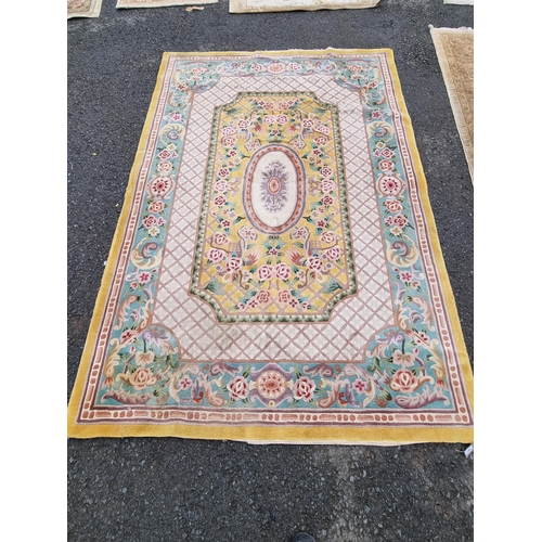 588 - A Chinese Rug with floral scrolls to the borders with central oval on a yellow ground, 9ft x 6ft