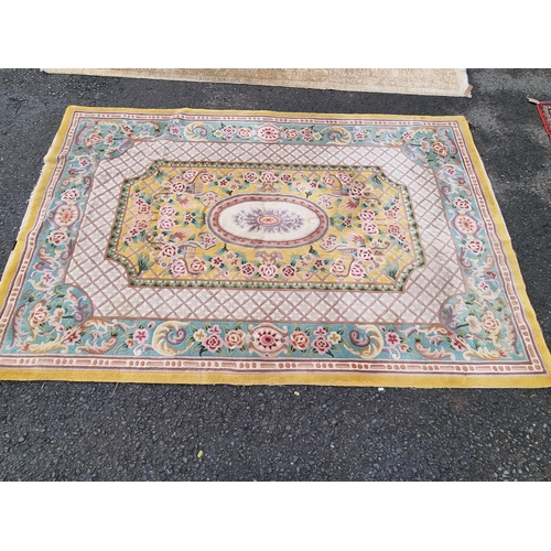 588 - A Chinese Rug with floral scrolls to the borders with central oval on a yellow ground, 9ft x 6ft