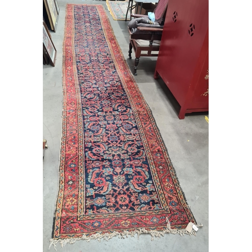 592 - A long antique Persian Runner, mutli-bordered, the centre with floral designs on a blue ground, 20ft... 