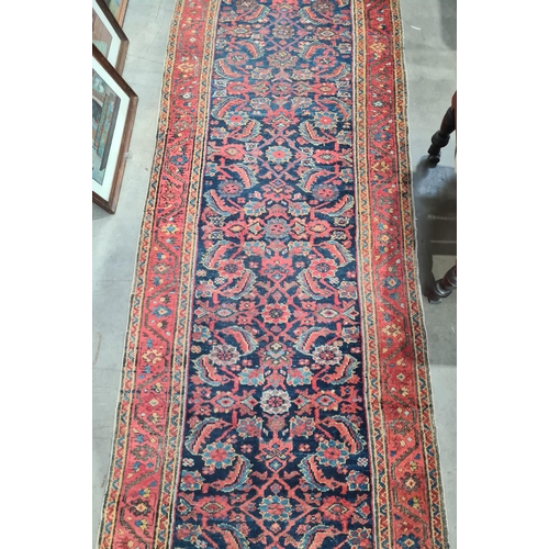 592 - A long antique Persian Runner, mutli-bordered, the centre with floral designs on a blue ground, 20ft... 