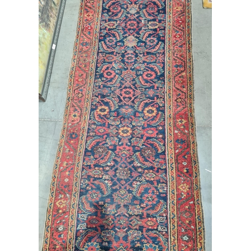 592 - A long antique Persian Runner, mutli-bordered, the centre with floral designs on a blue ground, 20ft... 