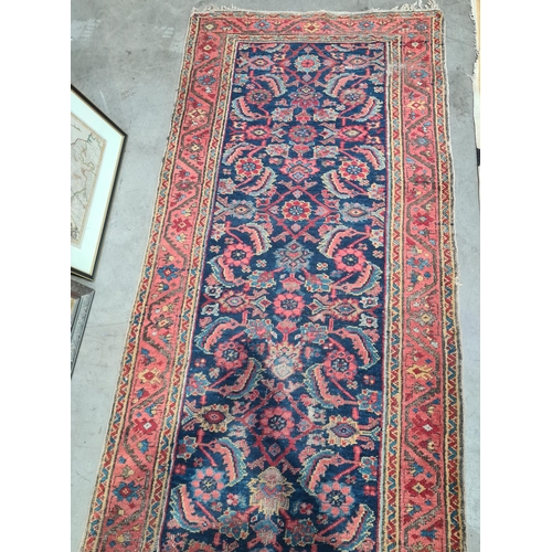 592 - A long antique Persian Runner, mutli-bordered, the centre with floral designs on a blue ground, 20ft... 