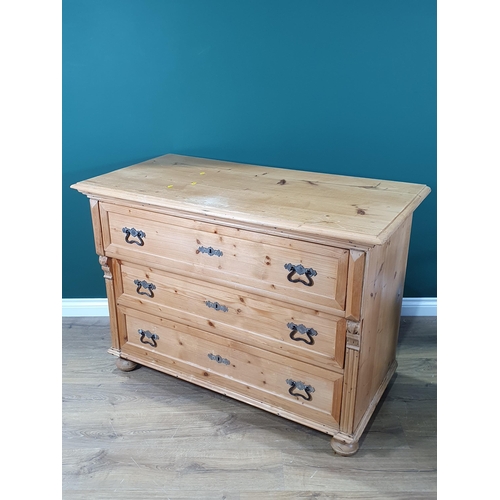 650 - A Continental pine Chest of three long drawers with moulded top, applied carved decoration on turned... 