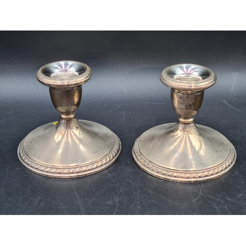 103 - A pair of Cartier sterling silver squat Candlesticks on circular bases with gadroon rims, 3 1/2in. m... 