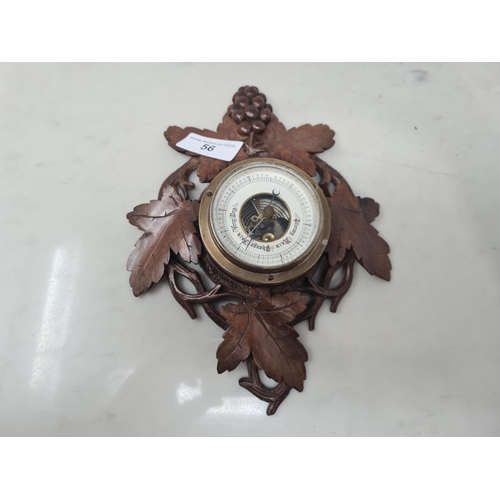 56 - An Aneroid Barometer in fruiting vine carved case, 10in, a pierced bone Fan , etc