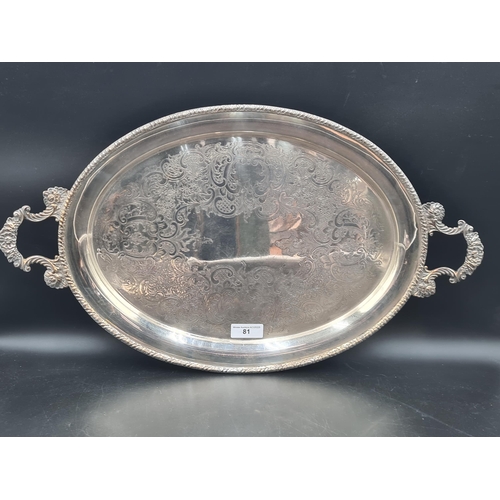 81 - A plated on copper oval two handled Tea Tray with scroll engraving and gadroon rim, 25in