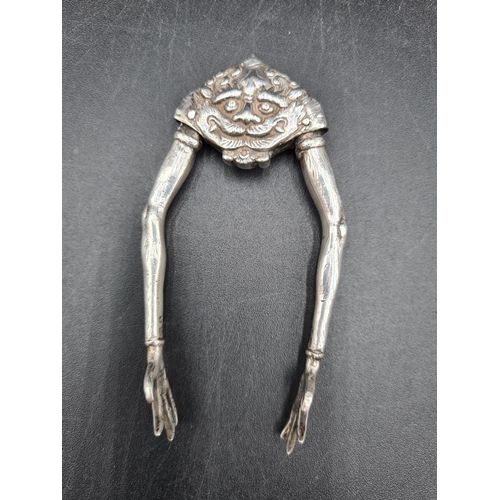 86 - A pair of George V Novelty silver Sugar Tongs with mask and claw design, London 1926