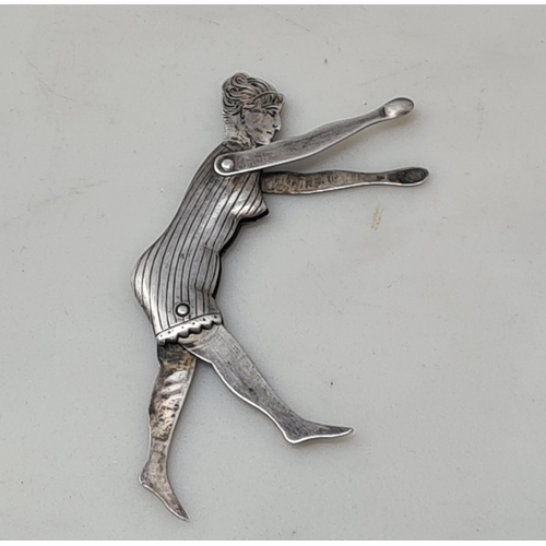 98 - An Art Deco white metal Figure of a Bather with engraved head and folding limbs, and a Figure of Pun... 