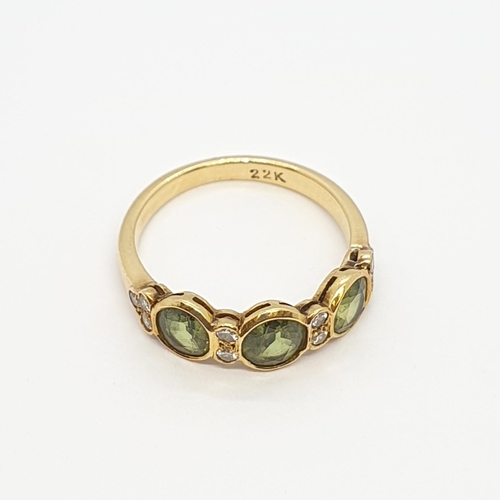 149 - A Peridot and Diamond Dress Ring, rubover-set round mixed-cut peridots between pairs and triplets of... 