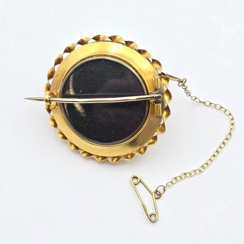 164 - A fine Victorian Etruscan Revival target Mourning Brooch set garnet cabochons, the central garnet ca... 