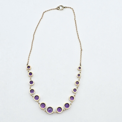 167 - An Amethyst Necklace, fourteen rubover-set round mixed-cut graduated amethysts on a rose gold colour... 