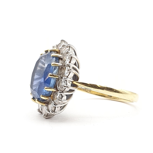 179 - A Sapphire and Diamond Cluster Ring, claw-set oval mixed-cut sapphire surrounded by fourteen claw-se... 