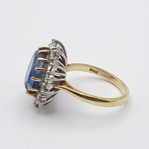 179 - A Sapphire and Diamond Cluster Ring, claw-set oval mixed-cut sapphire surrounded by fourteen claw-se... 