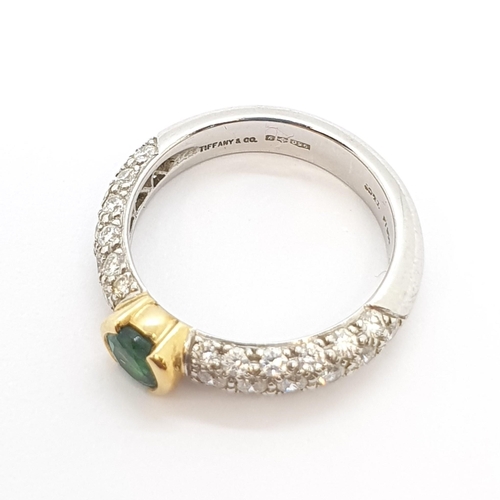 180 - An Emerald and Diamond Ring by Tiffany & Co, half-rubover-set round mixed-cut emerald in yellow gold... 