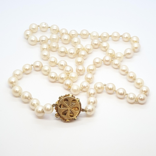 181 - A string of Cultured Pearls on yellow metal clasp set green cabochon stones and cultured pearl stamp... 