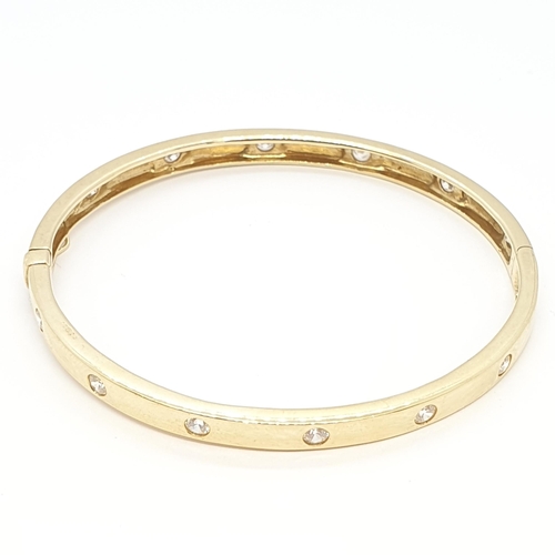 211 - A hinged yellow metal Bangle set cz, stamped 14K, approx 15.6gms