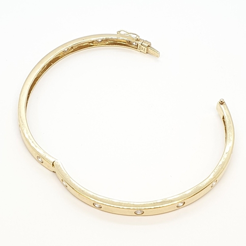 211 - A hinged yellow metal Bangle set cz, stamped 14K, approx 15.6gms