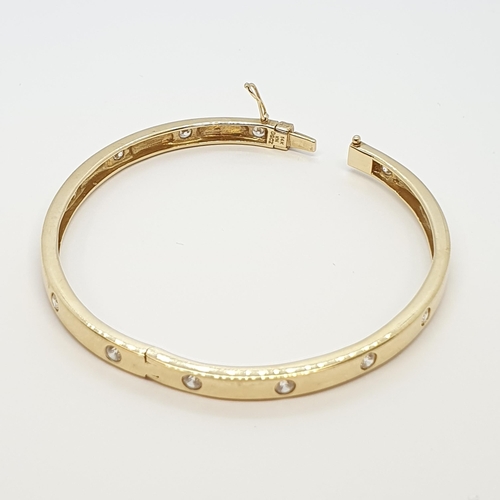 211 - A hinged yellow metal Bangle set cz, stamped 14K, approx 15.6gms