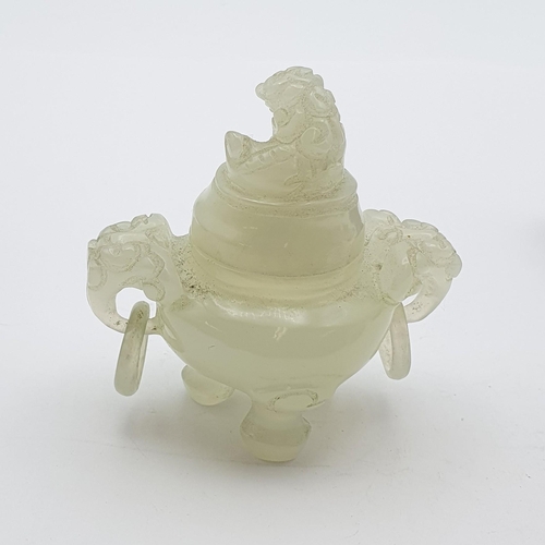 256 - A small carved jade type Jar and Cover with dog of fo finial, a pair of ring handles and raised on t... 