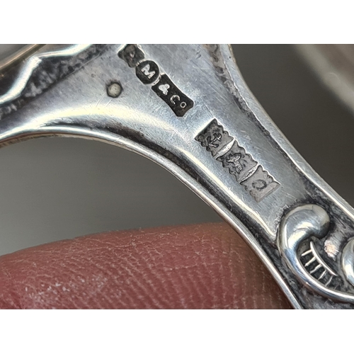 106 - An Elizabeth II silver Tea Strainer with floral stem, on stand, Birmingham 1963