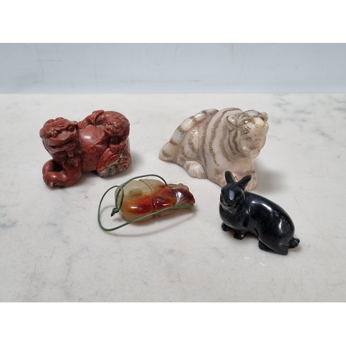 259 - A carved black stone figure of a rabbit, a stone figure of seated Tiger, a carved red stone figure o... 