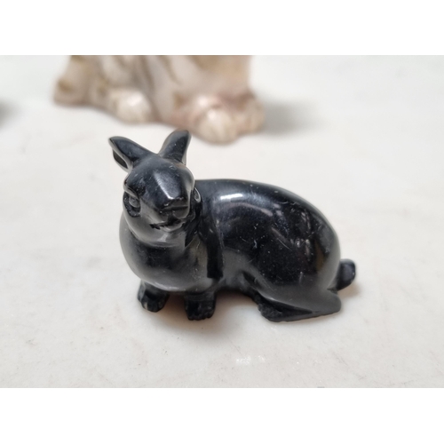 259 - A carved black stone figure of a rabbit, a stone figure of seated Tiger, a carved red stone figure o... 