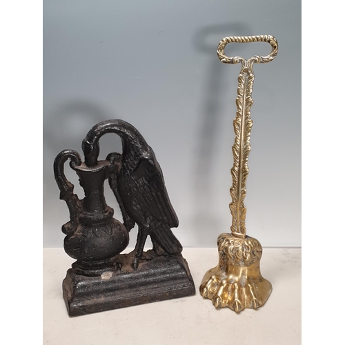 292 - A brass Door Porter with paw foot, and a cast iron Doorstop